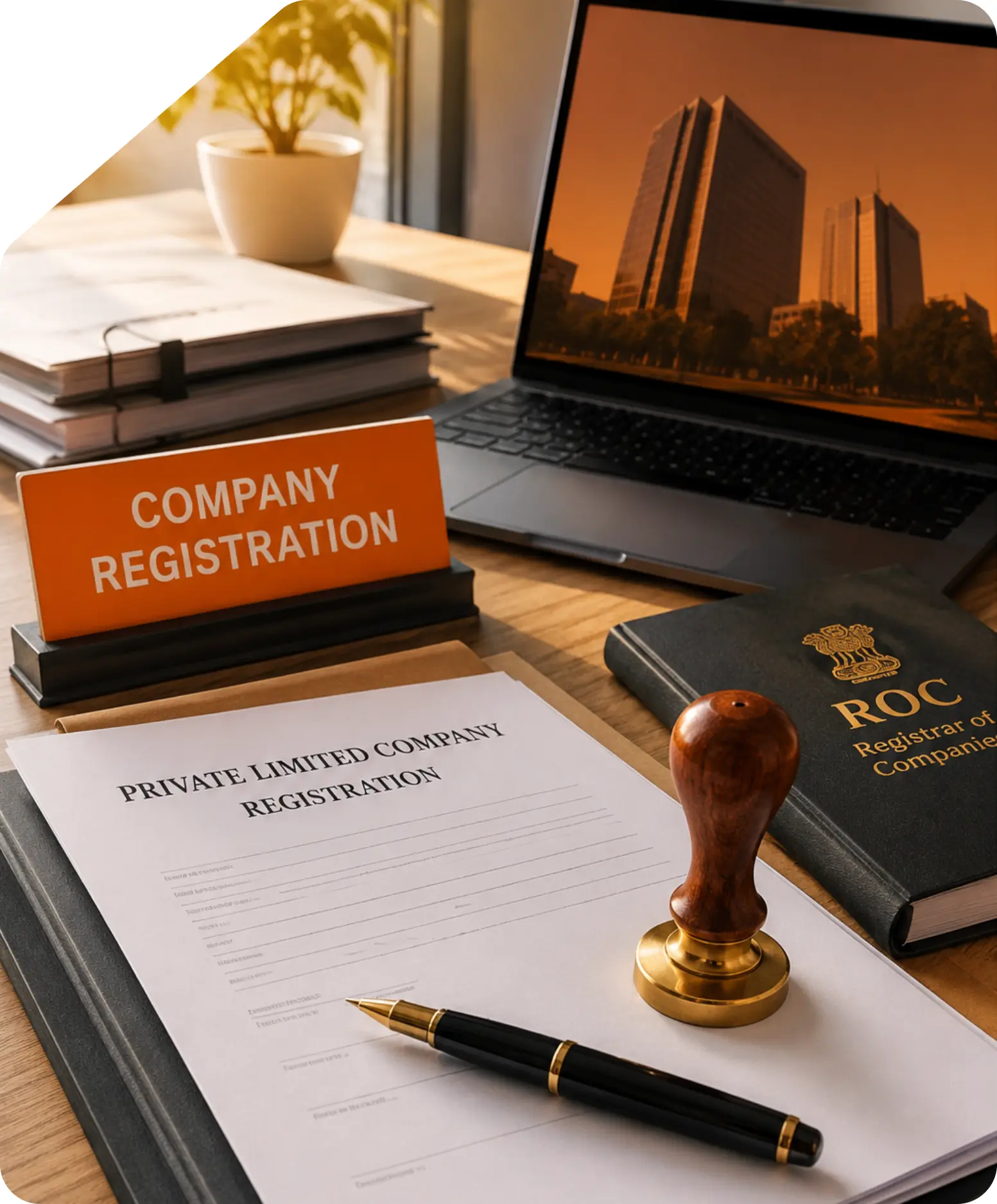 Company registration desk setup featuring a Private Limited Company Registration application form, ROC book, official stamp, pen, and laptop displaying a modern corporate office building.